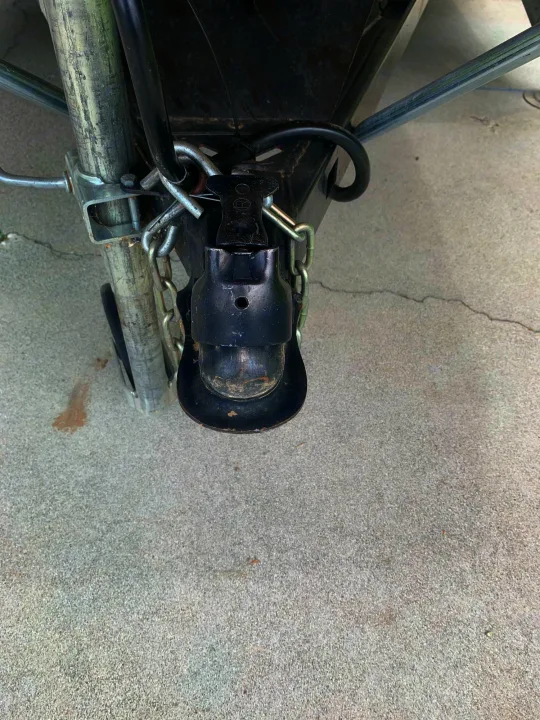 RV rental trailer hitch coupler and safety chains, connected to the A-frame on concrete.. Coachmen Sport 2007