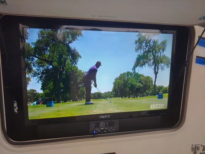 Enjoying PGA Tour golf on a built-in TV with an Axxera sound system in an rv rental.. Thor Motor Coach Vegas 24.1 2020