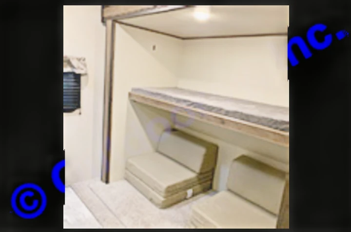 RV rental interior: A bunk bed is positioned above two convertible sofa seats, offering versatile sleeping and seating in a travel trailer.. Prime Time Avenger 2021