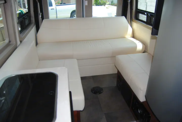 Spacious RV rental interior featuring plush white L-shaped seating, dark tiled floors, and large windows.. FL #44 Lexor 2020