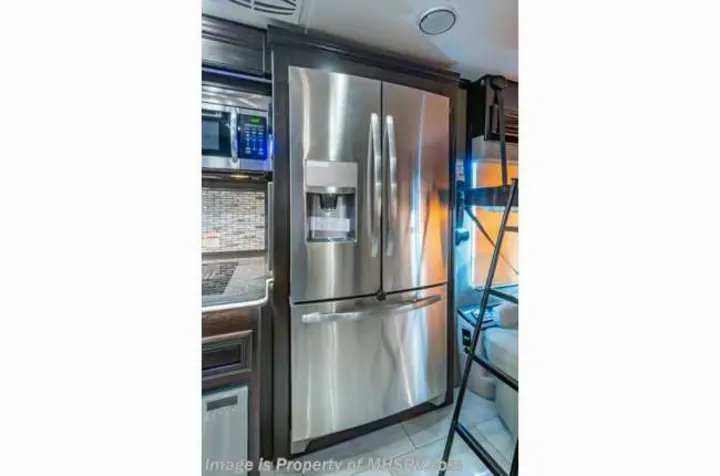RV rental kitchen featuring a stainless steel French door refrigerator, microwave, and ladder to bunks.. Forest River Berkshire 2020