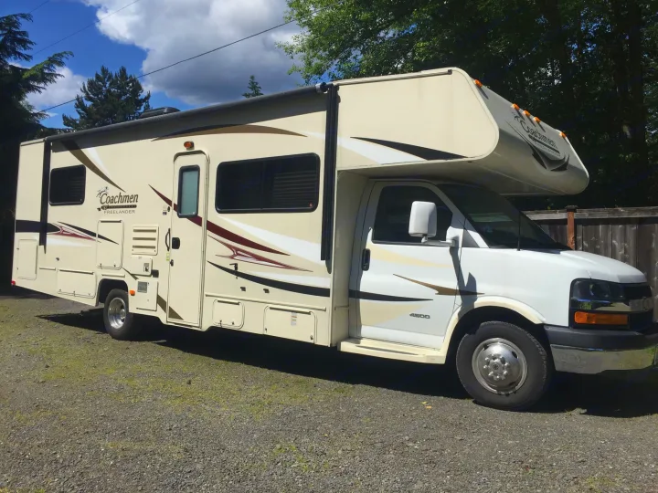 Cream Coachmen Freelander RV rental parked on gravel, with an extended slide-out. Ready for your next road trip adventure.. Coachmen Freelander 2014