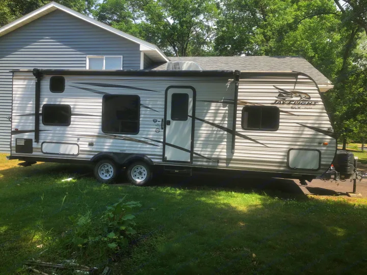 Light grey Jayco Jay Flight SLX travel trailer, perfect for your next RV rental adventure, parked outdoors.. Jayco Jay Flight 2018
