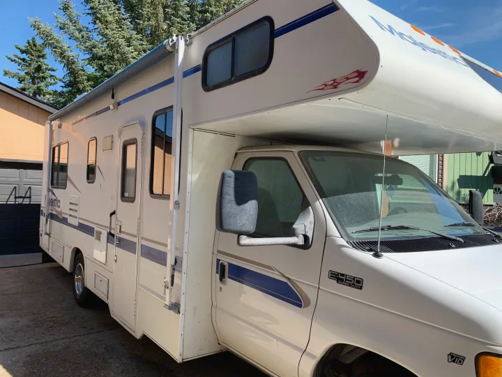 Side view of a white Class C rv rental, a Majestic motorhome built on a Ford E-450 chassis.. Majestic Leisure Craft E350 2001