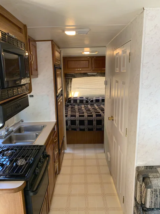 RV rental: Full kitchen with microwave, stove, double sink, and a cozy bedroom. Compact and ready for travel.. Majestic Leisure Craft E350 2001