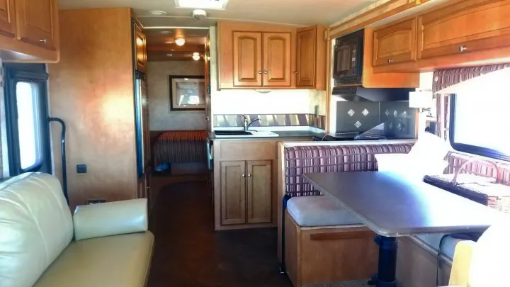 Bright RV rental interior with kitchen, dinette, and living area leading to the bedroom.. Winnebago Vista 2013