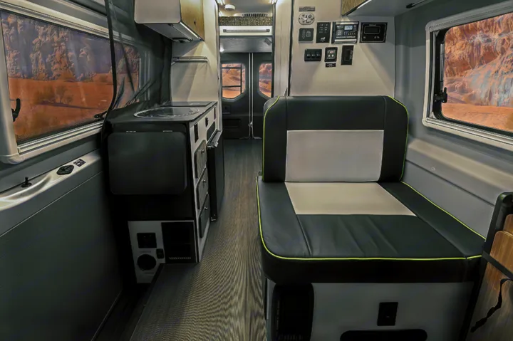 Step inside this modern RV rental: a compact camper van interior with kitchen, seating, and controls.. Winnebago Revel 2020