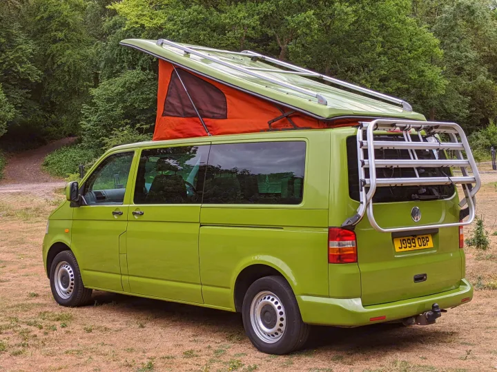 Bright green VW campervan with pop-top tent and rear bike rack, ready for your next outdoor RV rental adventure.. Volkswagen Other 2007