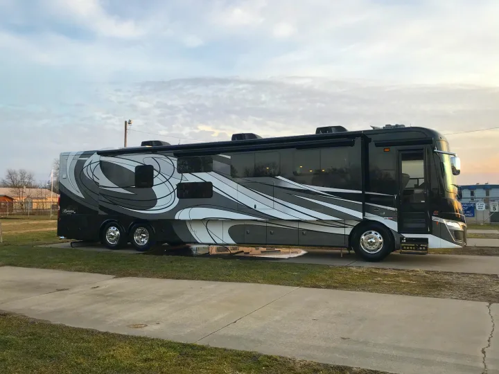 Sleek black and white Class A motorhome parked on concrete.. Forest River Berkshire 2020