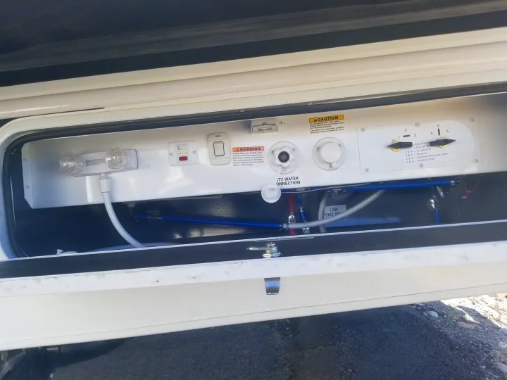 RV rental water system bay showing city water, pump, and multi-function valves for filling, sanitizing, and winterizing.. Entegra Coach Other 2021