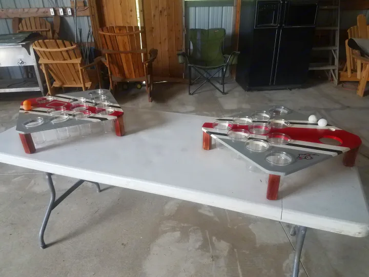 Beer pong tables set in a lively garage with chairs, fridge, and grill. Perfect for fun and games during an RV rental trip stop.. Heartland Pioneer 2016
