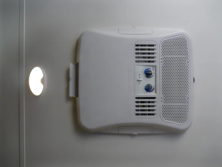 RV rental: Dometic air conditioner/heater unit with its control panel on a light ceiling, beside a bright circular light.. Gulf Stream Innsbruck 2016