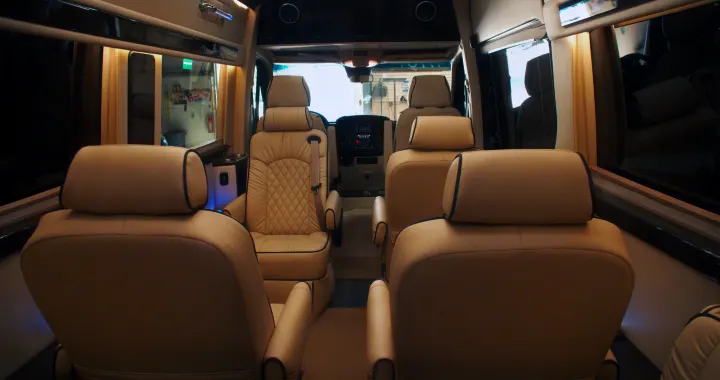 Luxurious cream leather interior of an RV rental, featuring multiple rows of spacious captain's chairs.. Other Other 2020