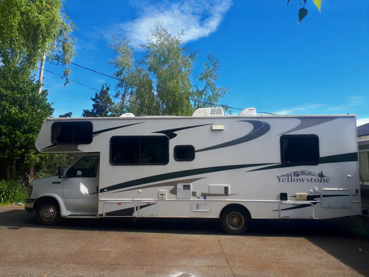 White Yellowstone RV parked outside under a blue sky, ideal for an rv rental adventure.. Other Other 2009