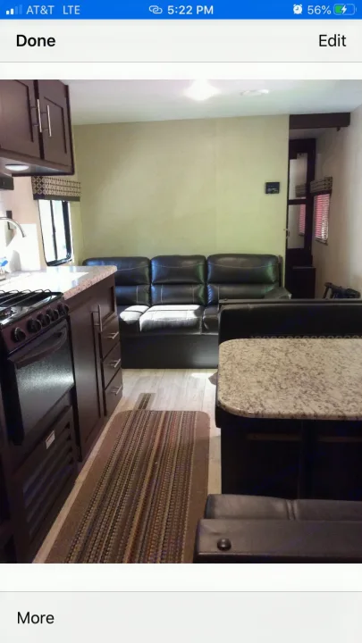 Modern RV rental interior with kitchen, black leather sofa, and granite-look dinette. Ready for your next adventure!. kz 26' SPORTSMAN 2018