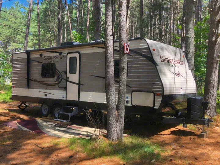 SPORTSMEN travel trailer RV rental at sunny campsite 13, nestled in a pine forest, ready for adventures.. kz 26' SPORTSMAN 2018