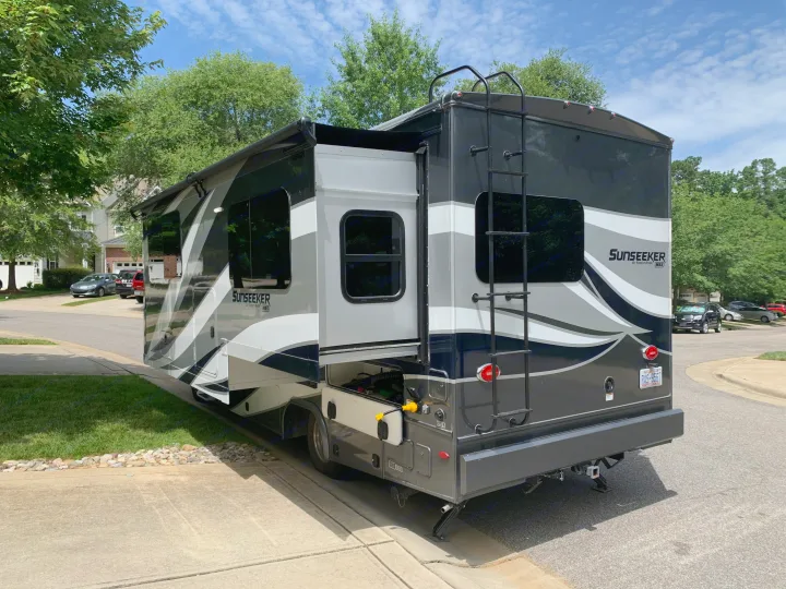 Sleek grey and black Sunseeker RV rental parked with slide-out extended and compartments open.. Forest River Sunseeker 2019