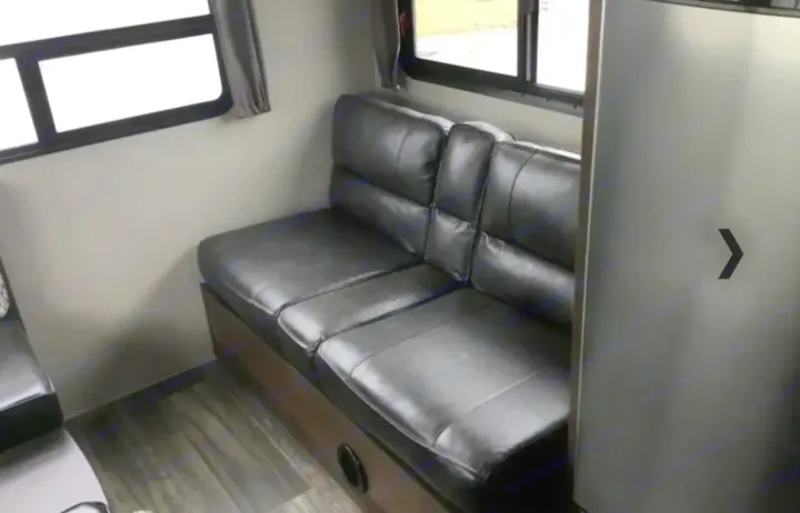 RV rental interior: black leather dinette seating, large windows, and a refrigerator visible. Comfortable and ready for travel.. Shasta Oasis 2019