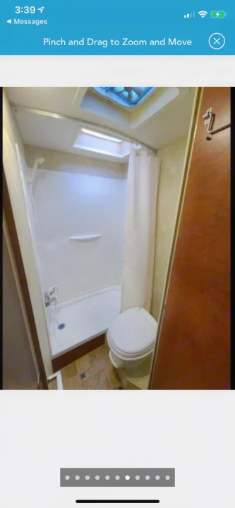 An RV rental's efficient bathroom: includes a white shower stall, toilet, and an overhead skylight for natural light.. Northwood Mfg Nash 2014