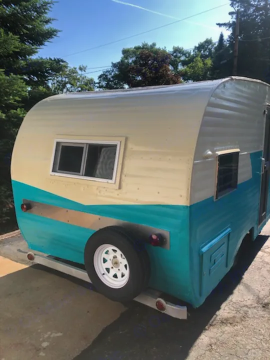 Explore with this charming vintage RV rental! Teal & cream camper with rear spare tire, ready for adventure.. Nomad Rear fold 1962
