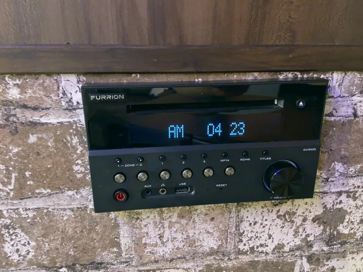 An RV rental's Furrion DV3100 stereo system, displaying AM 04:23, with various audio controls and inputs.. Forest River Cherokee Wolf Pack 2019