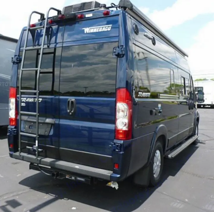 Dark blue Winnebago Travato camper van, perfect for rv rental, showing its rear ladder, hitch, and side profile.. Winnebago Travato 2020