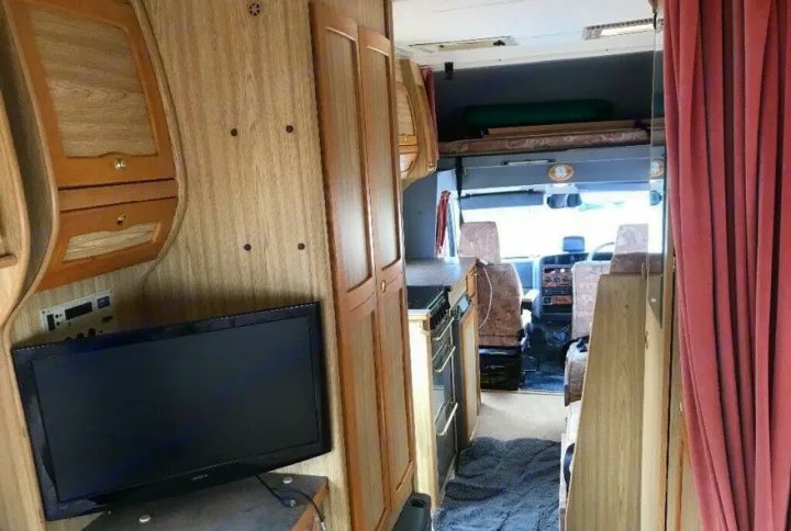 RV rental: Spacious motorhome interior featuring a lounge, TV, kitchen, and overhead sleeping area.. Peugeot Boxer Elddis Auto Stratus EB 1999