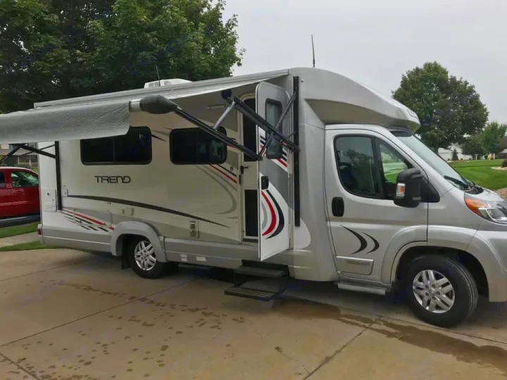 Silver Winnebago Trend RV rental, a Class C motorhome, parked with awning extended, ready for adventure.. Winnebago Trend 2017