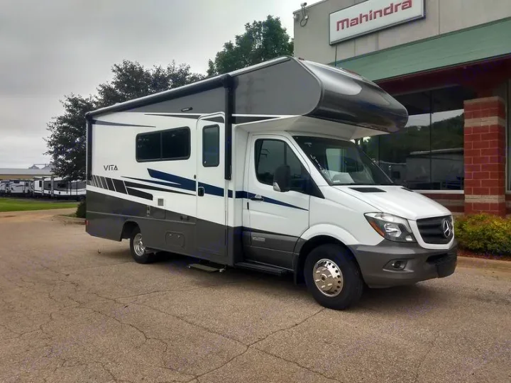 Spacious white and grey Class C motorhome, great for rv rental, parked outdoors at a sales lot.. Winnebago Vita 2020
