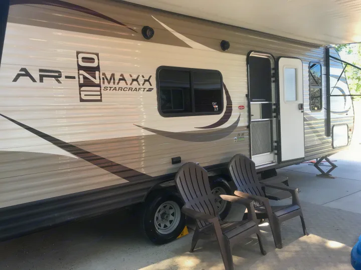 Parked Starcraft AR-ONE MAXX travel trailer rv rental, with outdoor chairs, ready for a relaxing trip.. Starcraft Ar-One 2017