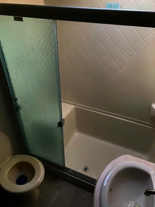 Compact RV rental bathroom featuring a toilet, textured glass shower, and corner sink. Clean and functional.. Palomino Columbus 2018
