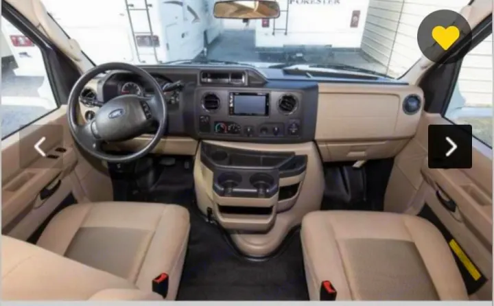 RV rental: Spacious interior cabin of a Ford RV, showing steering wheel, dashboard, and beige seats.. Thor Freedom Elite 2018