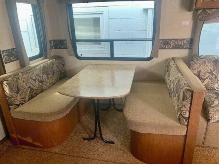 RV rental: Dinette booth with table & upholstered seating, ready for meals & relaxation on your journey.. Heartland Prowler 2012