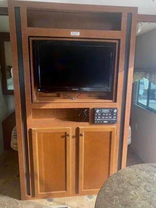 This RV rental offers a built-in entertainment center with a flat-screen TV, audio system, and storage cabinets.. Heartland Prowler 2012