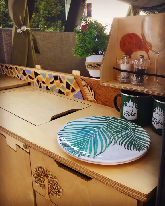 Cozy rv rental kitchen with light wood cabinetry, mosaic backsplash, "Take a Hike" mugs, and palm leaf plates.. Toyota Voxy 2004