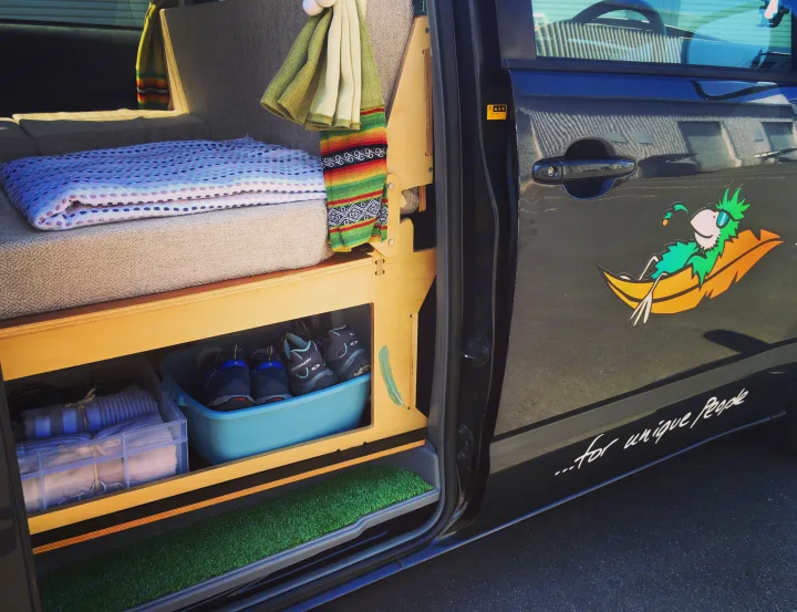 Custom RV rental camper with cozy bed, shoe/linen storage, and fun parrot door art for unique travelers.. Toyota Voxy 2004