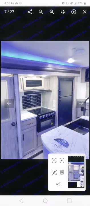 Modern RV rental kitchen featuring black appliances, marble-look counters, a large sink, and blue LED accents.. Forest River Cherokee Alpha Wolf 2021
