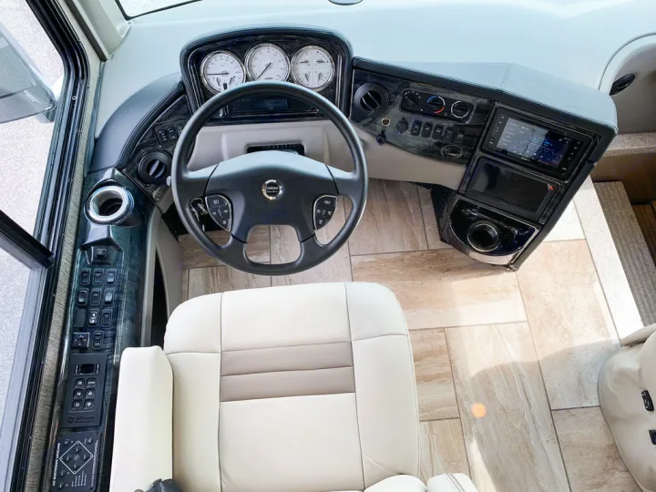 Spacious RV rental cockpit featuring a modern dashboard, steering wheel, and comfortable driver's seat.. Thor Motor Coach Tuscany 2019