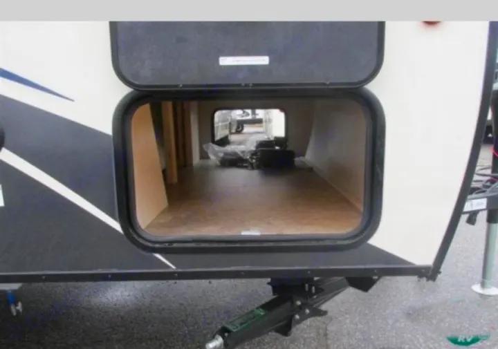 RV rental: Open pass-through storage compartment of a camper, showing interior space and a leveling jack.. Venture Rv Sonic Lite SL 169VRD 2018