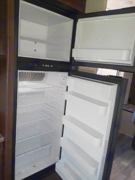 Clean, empty RV rental refrigerator. Both freezer and fridge doors are open, ready for your groceries.. Jayco Redhawk 2020
