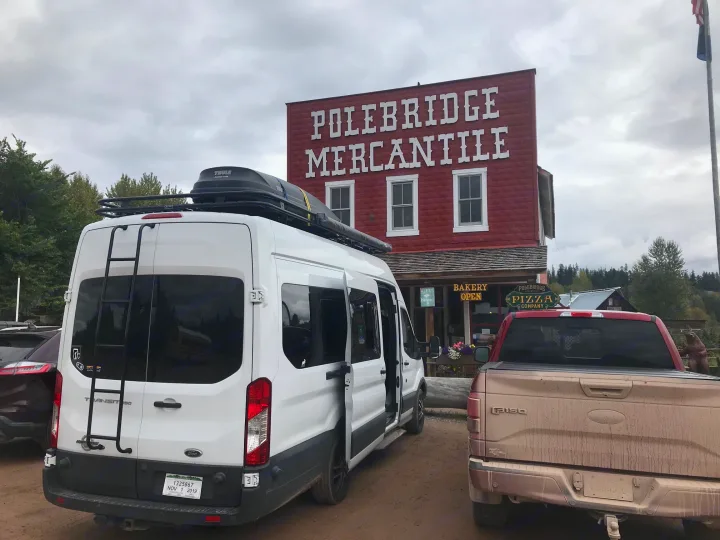 White Ford Transit RV rental parked at the rustic Polebridge Mercantile, a general store with bakery & pizza.. Ford Transit Custom 2015