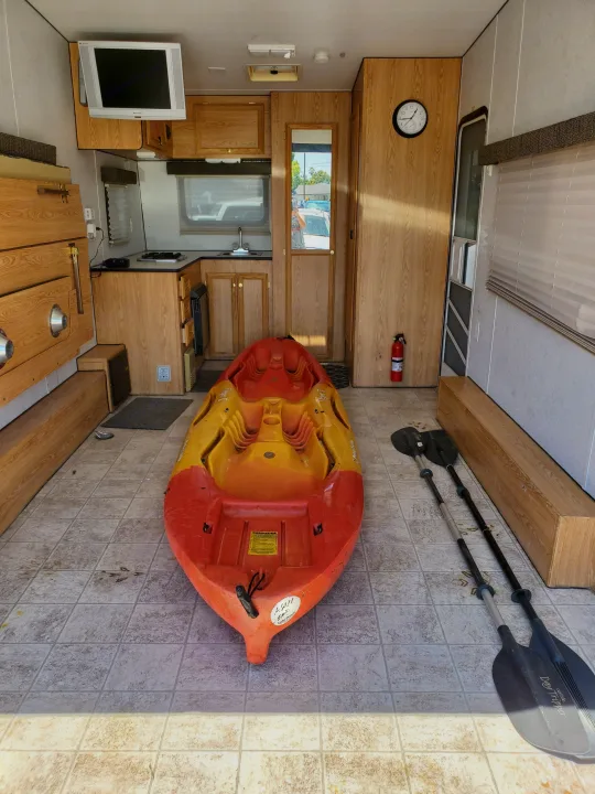 Inside this RV rental, a vibrant kayak and paddles await. Functional kitchen & storage make it ideal for travel adventures.. Carson Trailer Toy Hauler 2007