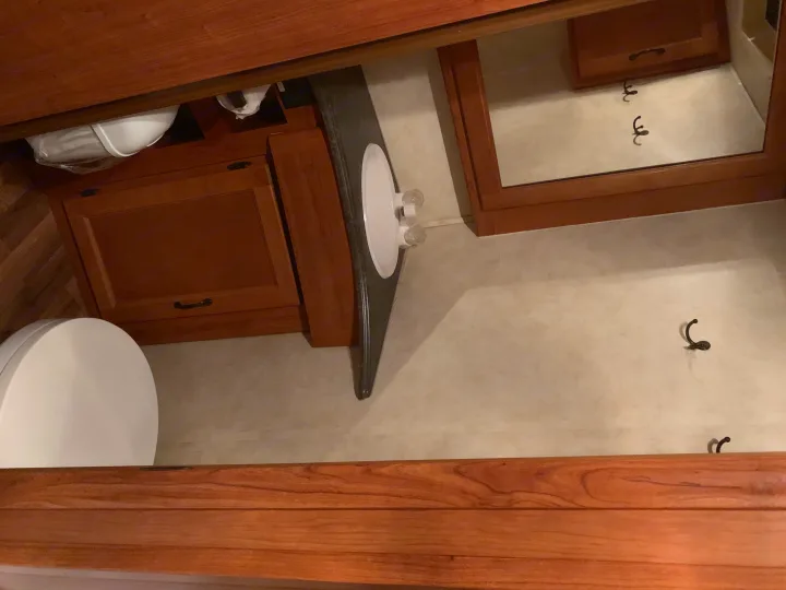 Well-appointed RV rental bathroom featuring a toilet, sink vanity, and wood cabinets for a comfortable stay.. Coachmen Freelander 2012