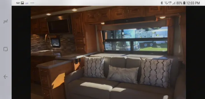RV rental showing a well-equipped kitchen with microwave and a cozy living area with sofa, ready for your next adventure.. American Coach 42B 2019