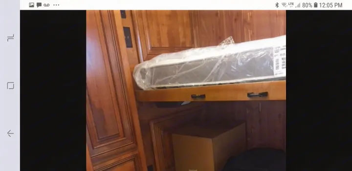 New, wrapped mattress on a bunk bed in an RV rental, with ample storage space below for your gear.. American Coach 42B 2019