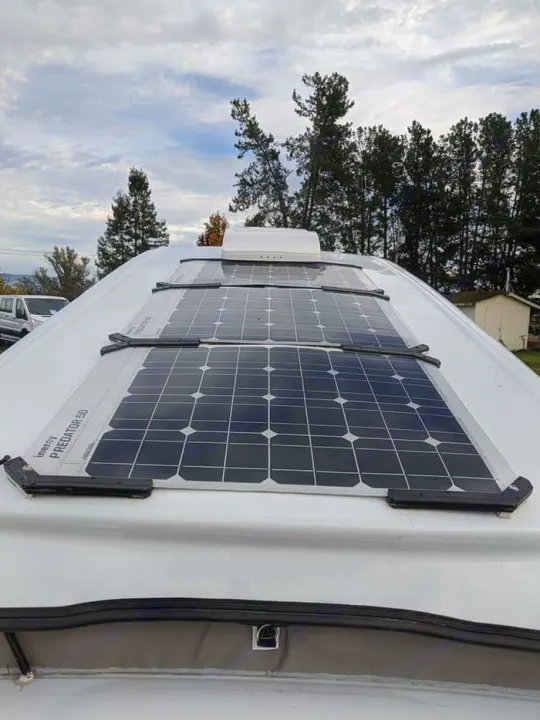 RV rental roof with multiple Inergy Predator 50 flexible solar panels, offering off-grid power under a cloudy sky.. Mercedes Metris 2016