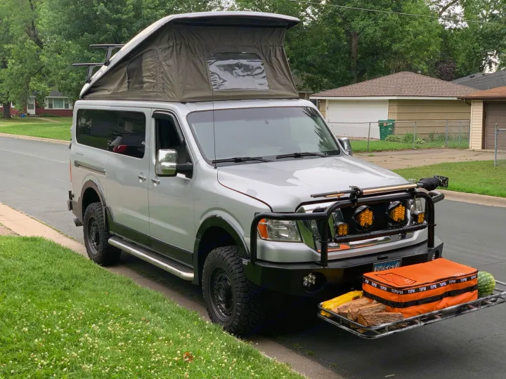 Silver pop-top camper van with front cargo rack and overland setup, ideal for your next RV rental adventure.. Roadtrek N6-Active 2013