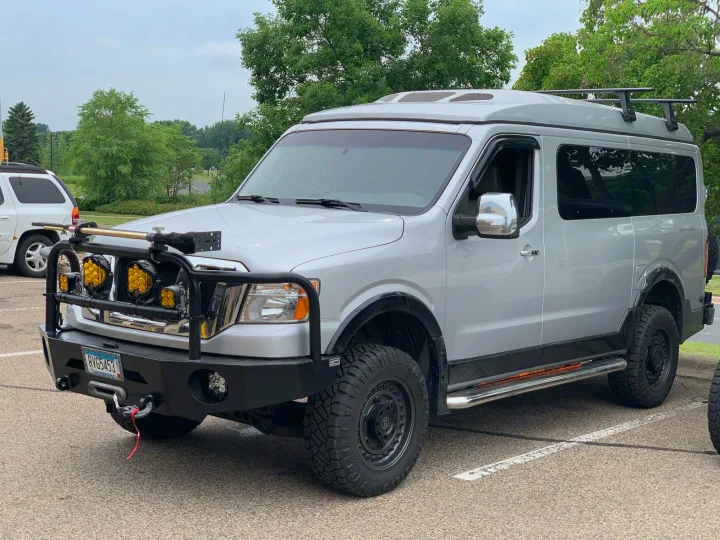 Rugged silver Nissan NV overland van with off-road tires and custom gear, ideal for your next RV rental adventure.. Roadtrek N6-Active 2013