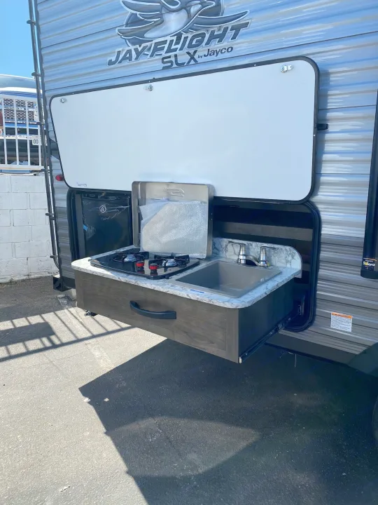 This RV rental features a convenient pull-out outdoor kitchen with a stove and sink, perfect for camping adventures.. Jayco Jay Flight 2020