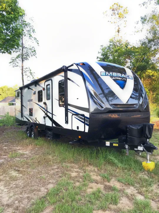 White, black & blue 'EMBRACE ULTRA-LITE' travel trailer for RV rental. Parked outdoors, ready for your next adventure.. Other Other 2018